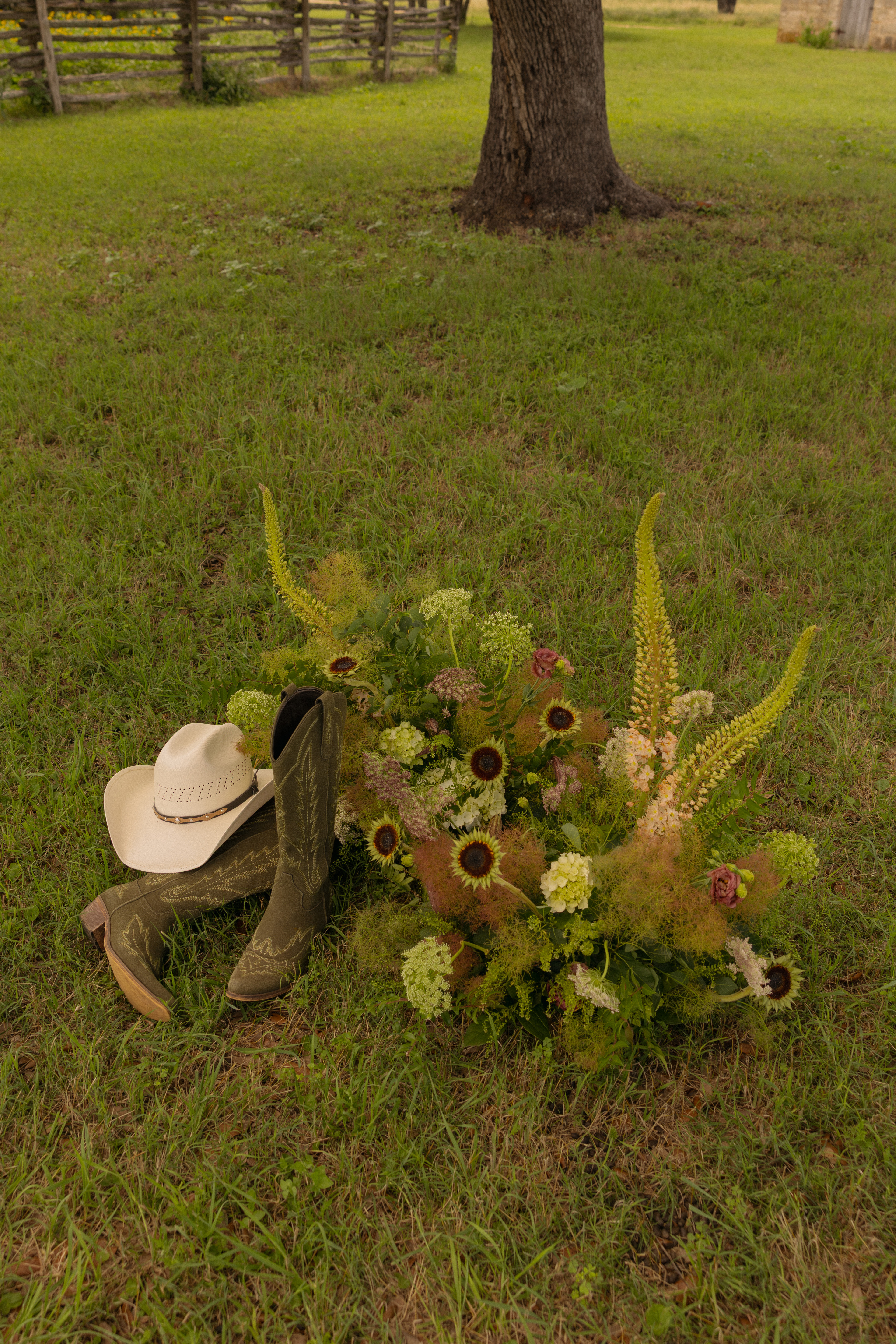 Boots, hat, and flowers in the grass