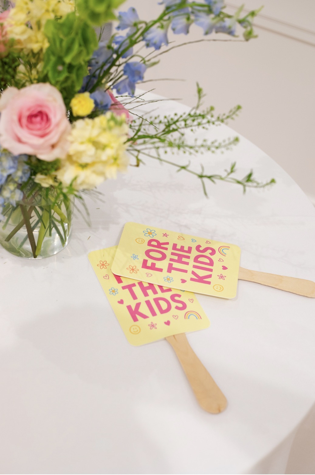Pink, yellow, and blue flowers beside For the Kids paddles