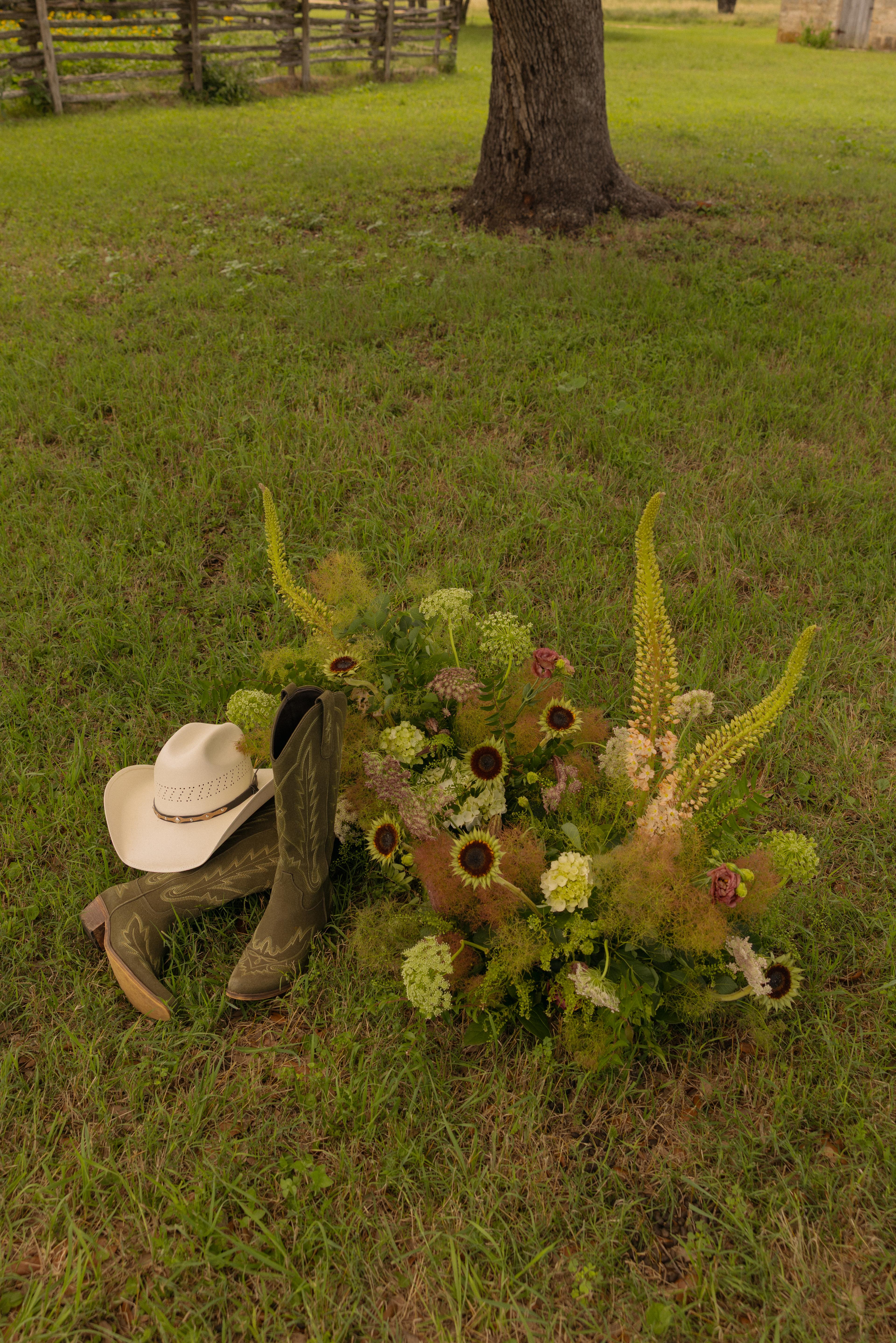 Boots, hat, and flowers in the grass