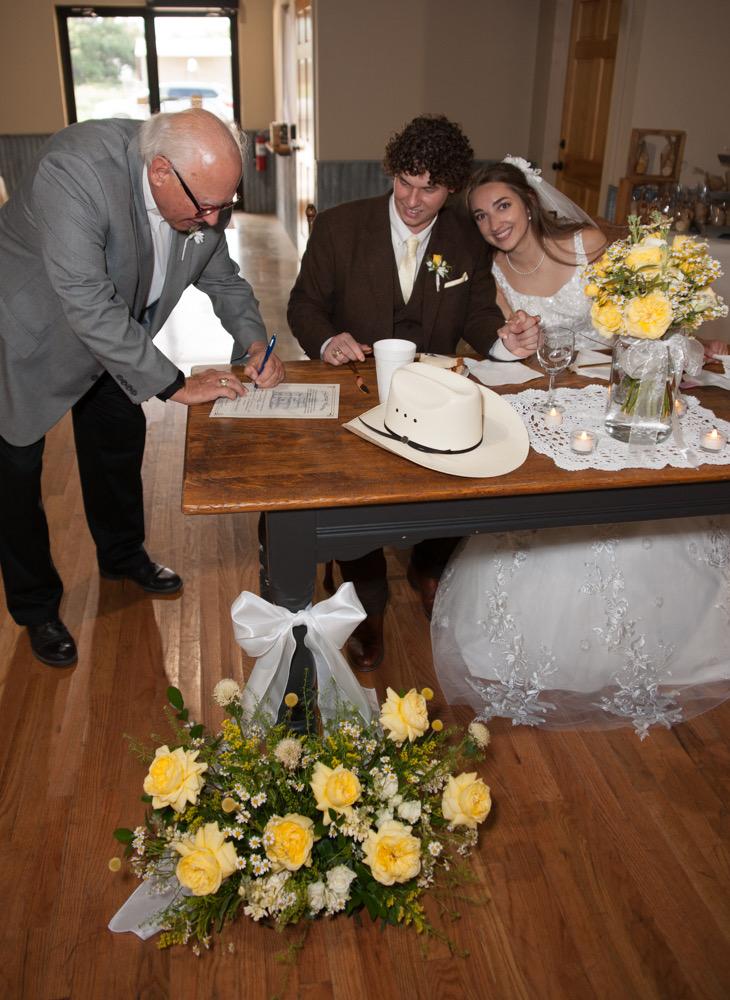 Whitney and Cade signing wedding documents